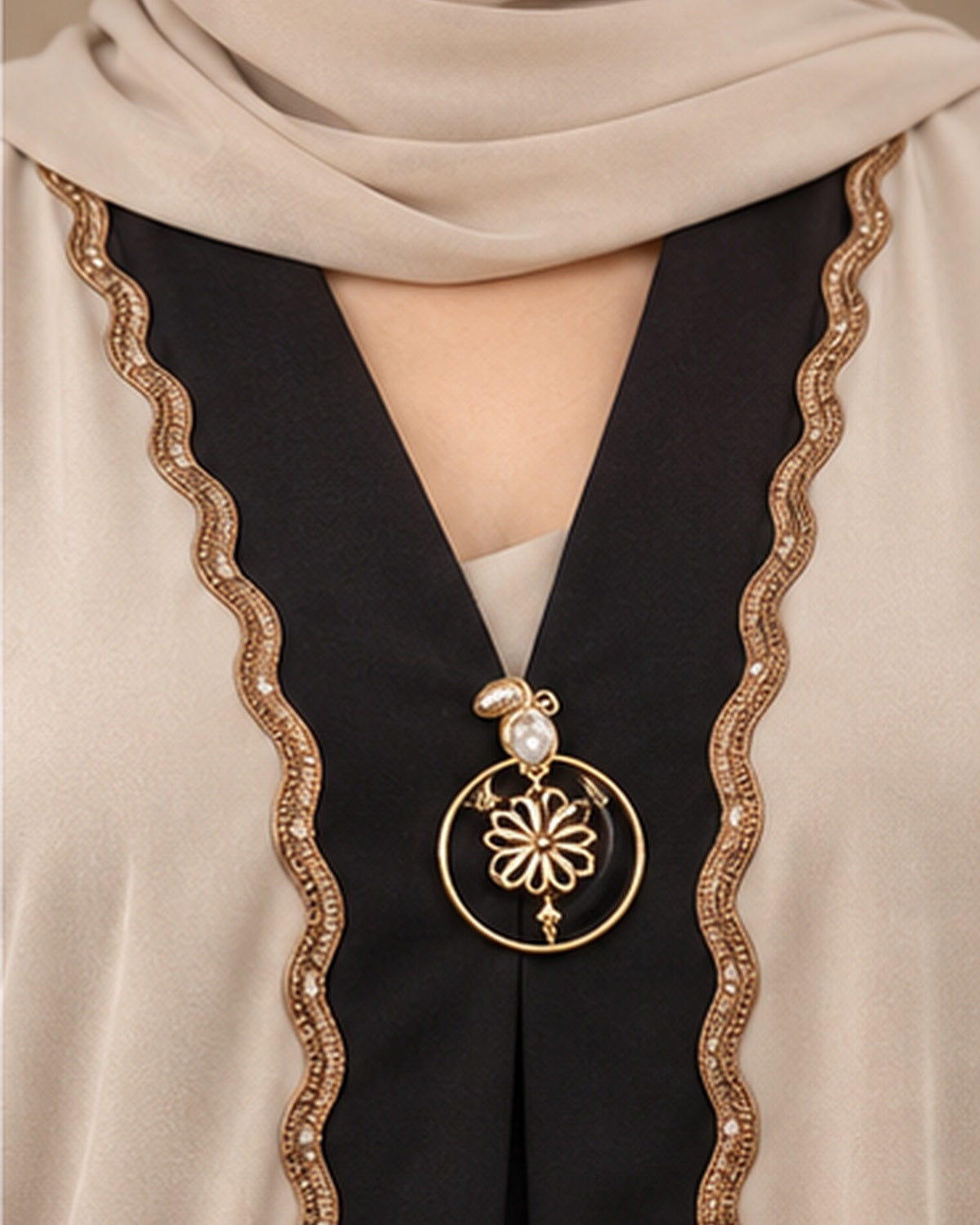 Ivory abaya black center panel and gold pendant detail